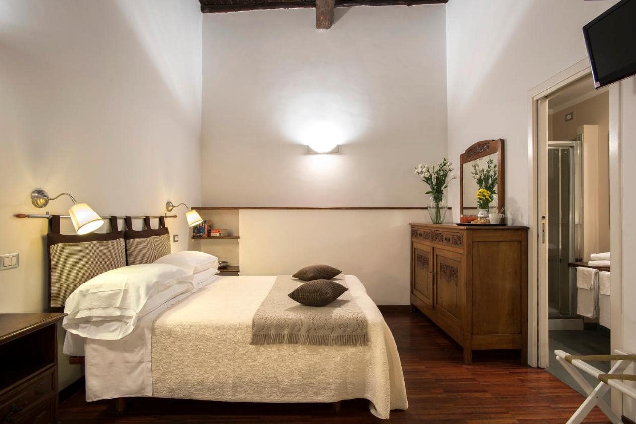 Une chambre sous poutres, salle de bains attenante. © Arco del Lauro