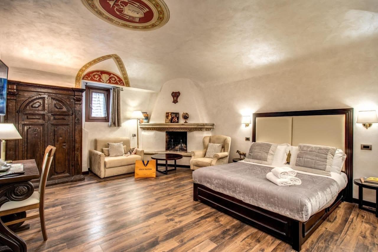 Une chambre, fresques et poutres. © Boutique Relais Barozzi