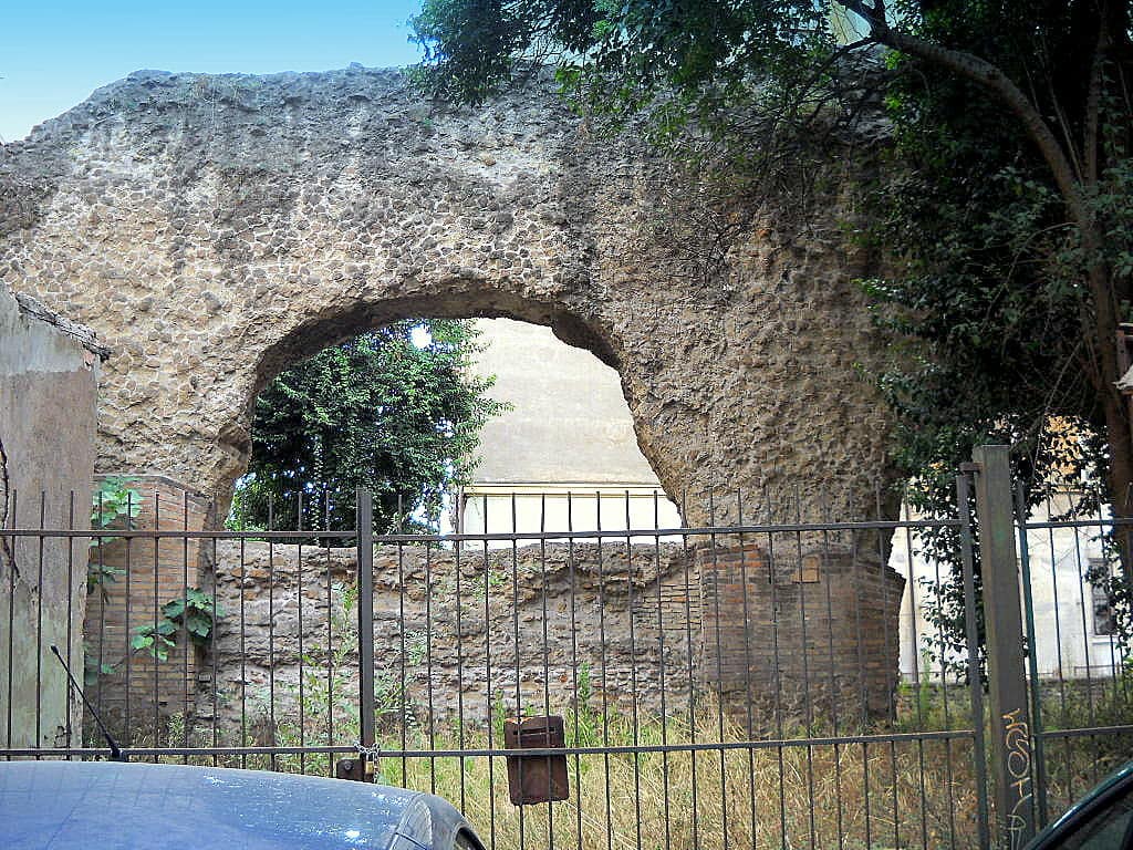 Arche en béton romain de la Porticus Aemilia, derrière une grille, dans une rue de Testaccio