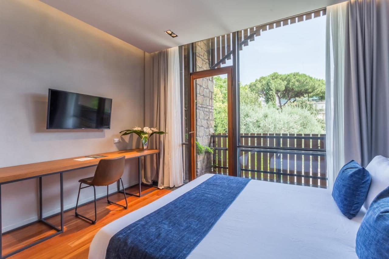 Une chambre avec balcon sur la verdure. © Fauno Urban Resort