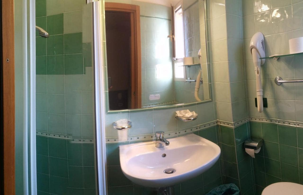 Une salle de bains carrelée de vert. © Hotel Prati