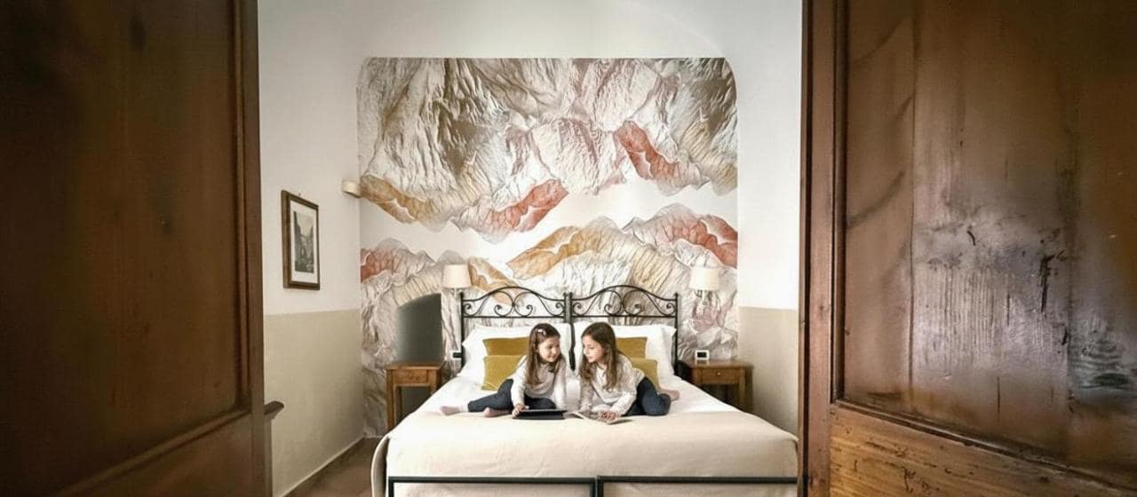Une chambre et sa tête de lit à fresque. © Le Clarisse Trastevere
