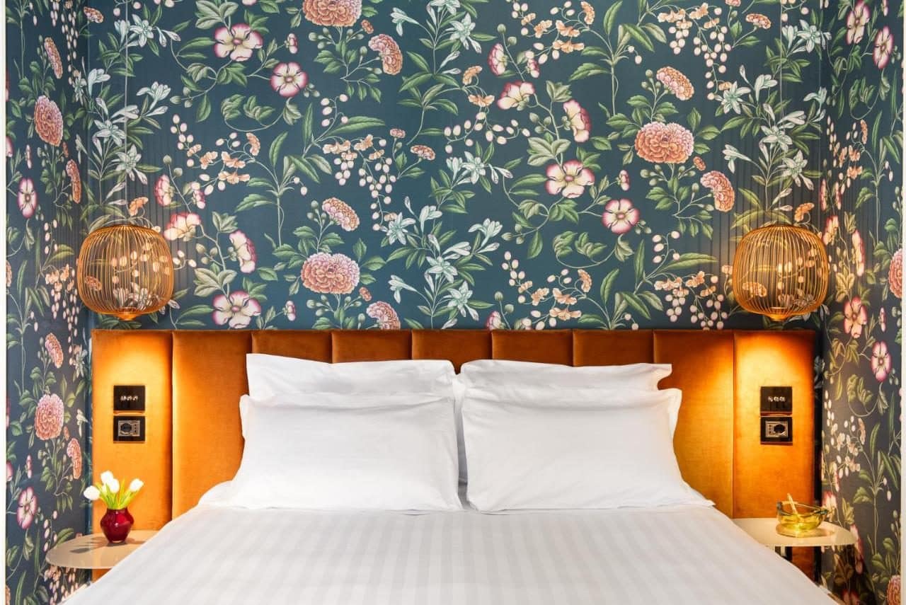 Une chambre, papier peint fleuri. © Nus Hotel Poerio